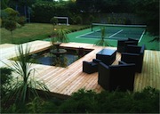 In this large garden in Hove, Sussex, a new tennis court meant that an area of old paving around a pond needed a rethink. The design helped to rejuvenate the garden combining timber decking and extended areas of structural evergreen plants in the new garden.